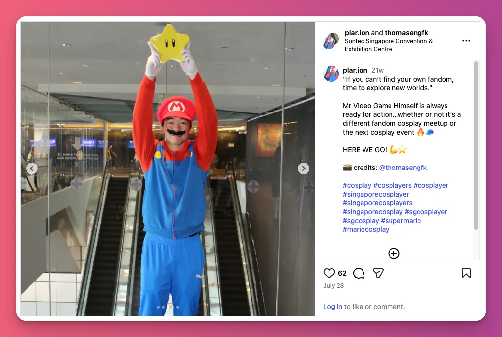 Mario cosplay at a convention wearing a red shirt, blue tracksuit, and 'M' hat while holding a yellow Starman prop high